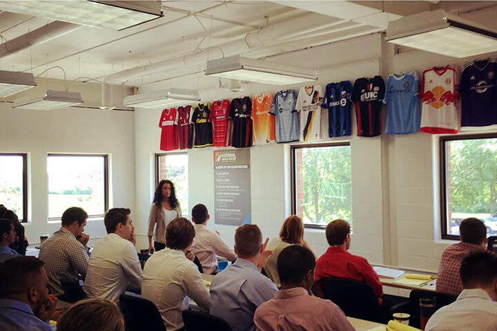 MLS Training Session with participants sitting in a classroom and a speaker at the front