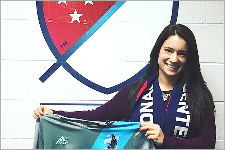Melanie Seiser holding up a Minnesota United FC jersey