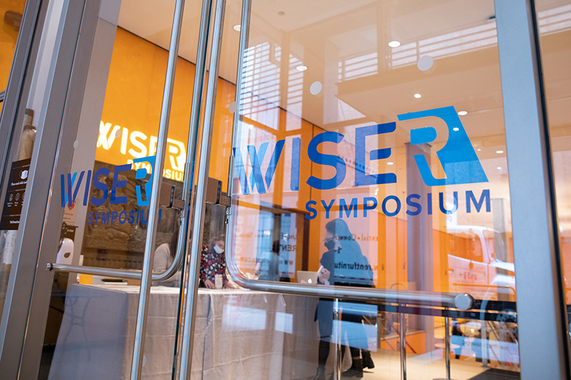 WISE/R Symposium Logo posted on a glass door