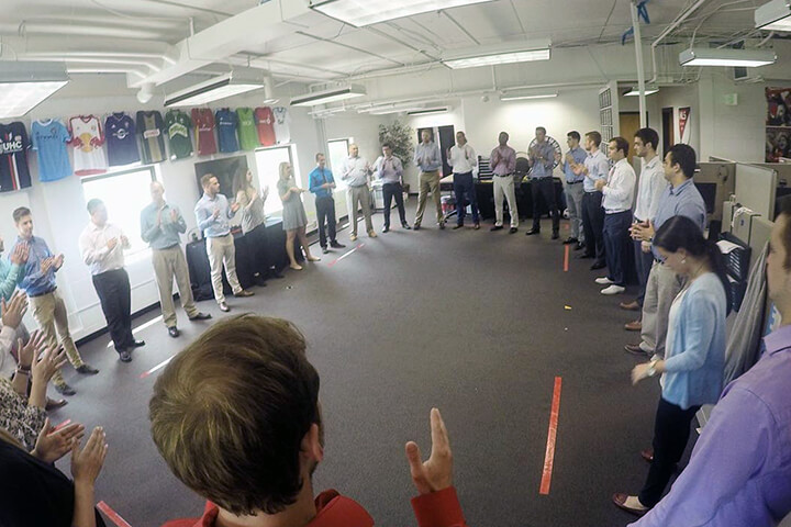 Group activity at the Major League Soccer National Sales Center where participants are standing in a circle and clapping their hands
