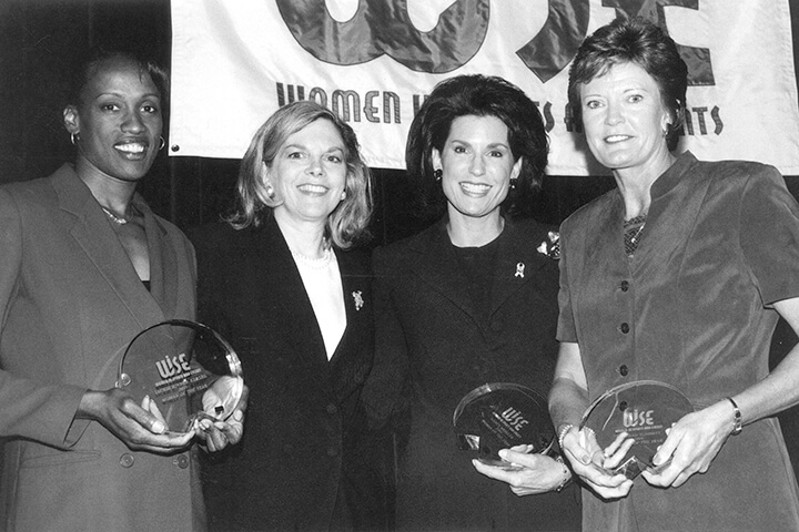 Jackie Joyner­-Kersee, Nancy Brinker and Pat Summitt holding awards and standing with WISE founder Sue Rodin