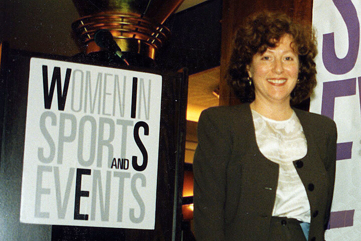 Sara Levinson standing next to the Women In Sports and Events signage