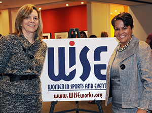 Kathleen Francis (right), Sue Rodin (left), WISE logo poster in the middle of them
