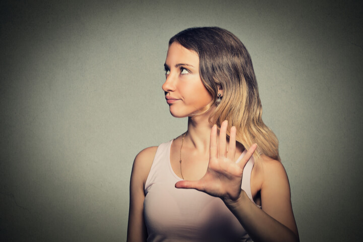 A woman looking annoyed giving someone "the hand"