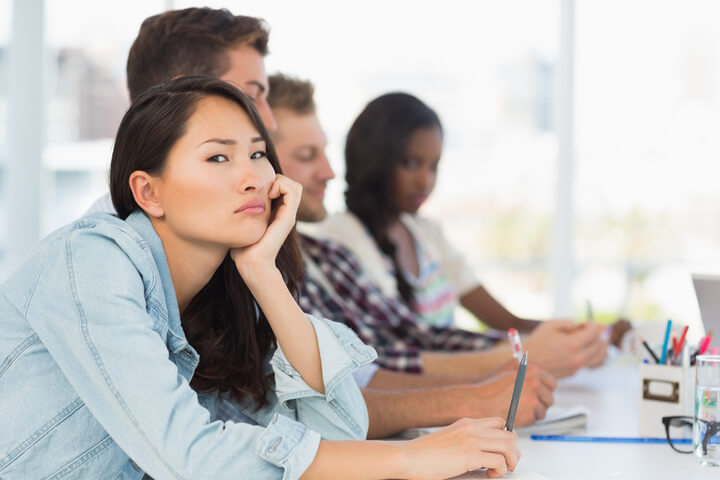 A woman in a school setting disinterested in the work