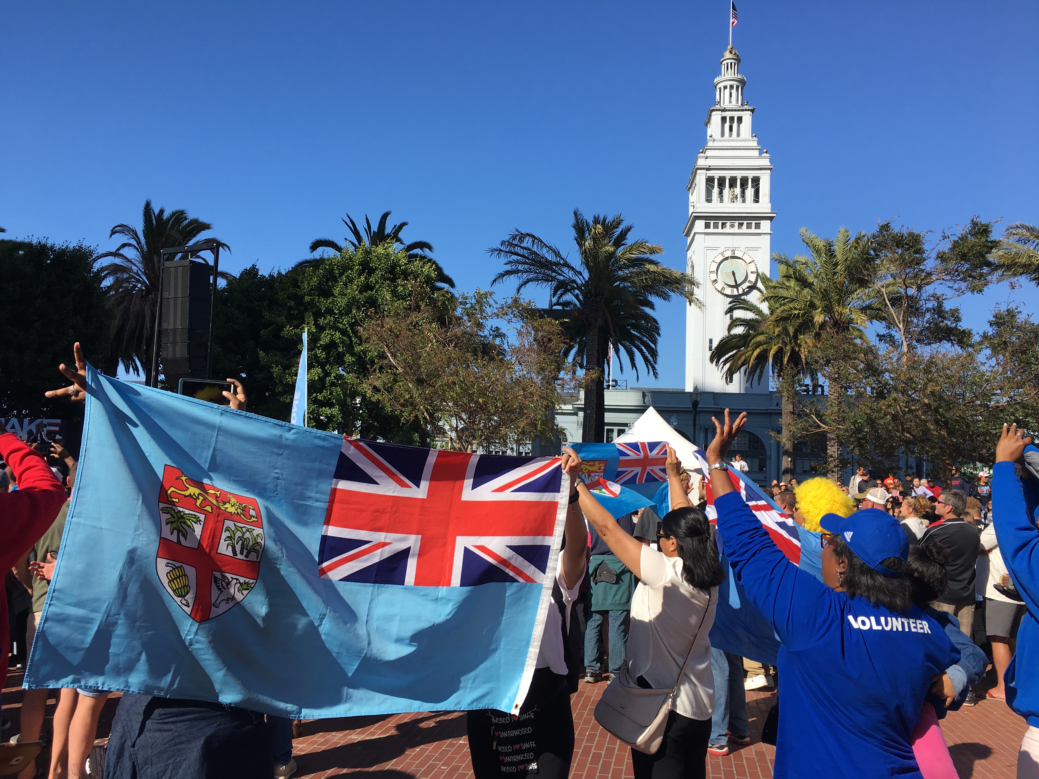 Crowd holding up flags and cheering on at the WISE SF Bay Area Rugby World Cup Sevens event