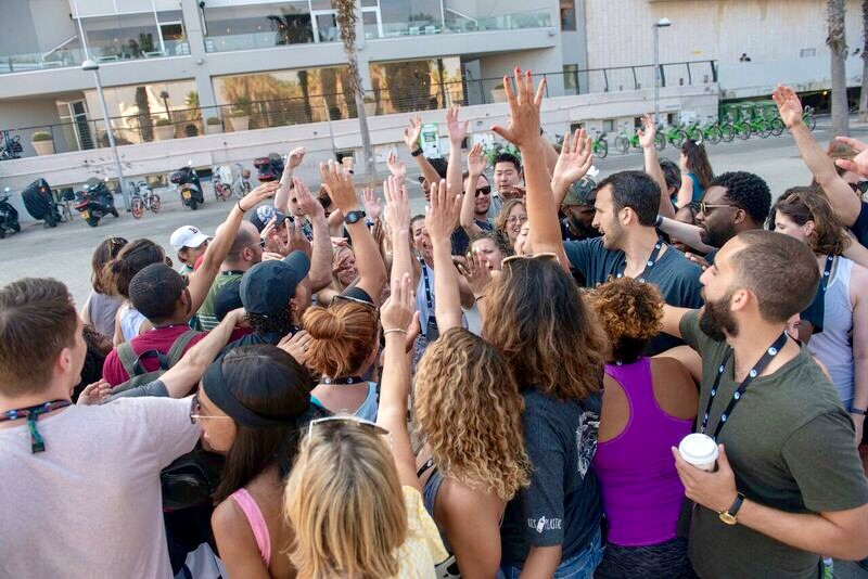 People holding up their hands at a Morning gratitude session in Tel Aviv