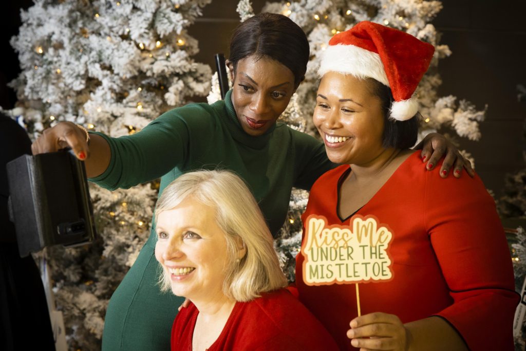 WISE NYC Metro members at 2019 Women of Inspiration event taking a selfie while one is holding a kiss me under the mistletoe sign
