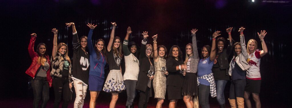 WISE NYC Metro members at 2015 Women of Inspiration event on stage imitating shooting a basketball
